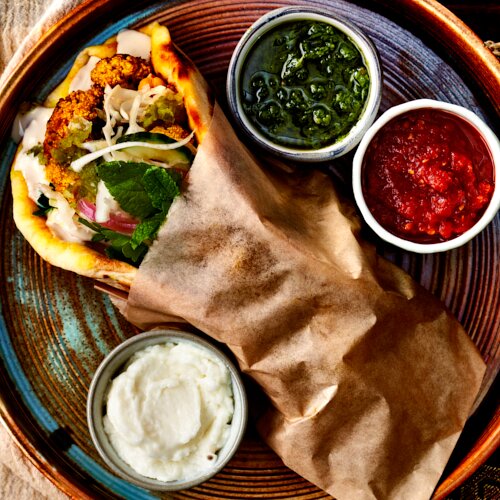 Vegetable Shawarma A flavorful vegetarian take on shawarma: Turmeric cauliflower served on flatbread with a mix of crunchy slaw, suma A flavorful vege